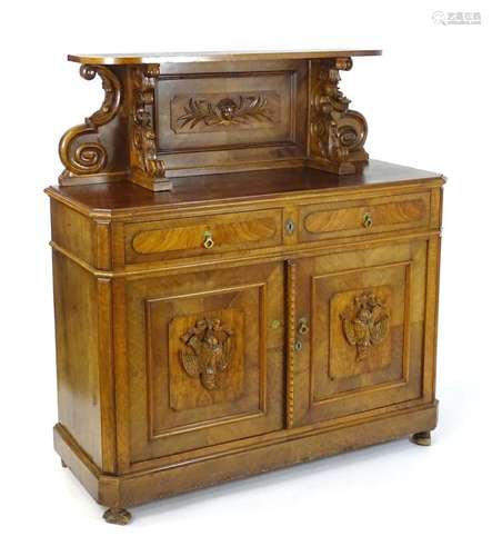 A late 19thC French walnut sideboard, having a heavily carve...