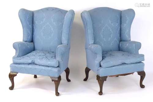 A pair of early 20thC wingback armchairs, each chair raised ...