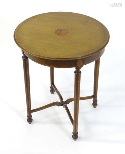 An Edwardian mahogany table with a circular moulded top deco...