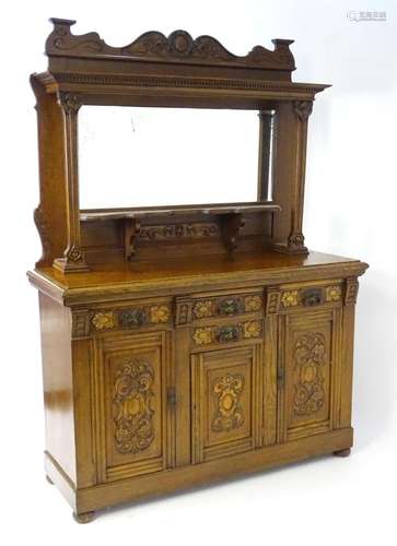 An oak Art Nouveau mirror back sideboard, having a shaped ca...