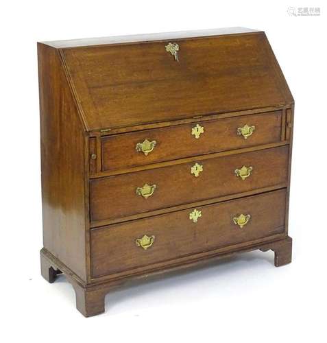 A Georgian oak bureau with a fall front above three long gra...