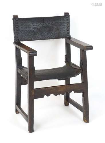 An 18thC Spanish open armchair with an embossed leather back...