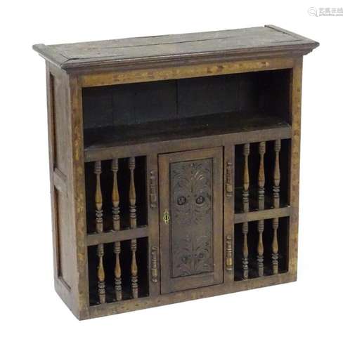 An 18thC oak wall cabinet with a moulded cornice above a fea...