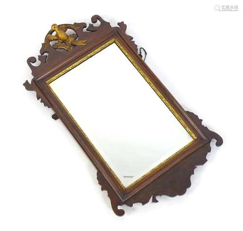 An early 20thC mahogany mirror with a pierced pediment surmo...