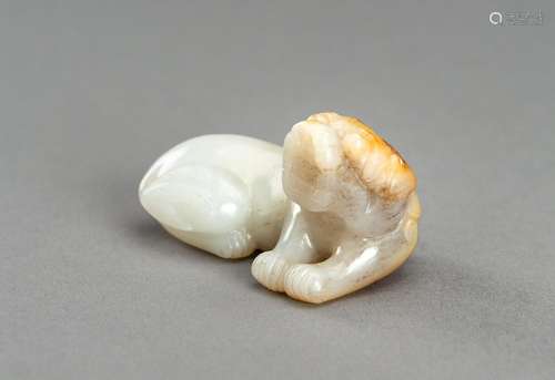 A WHITE AND RUSSET JADE CARVING OF A BUDDHIST LION