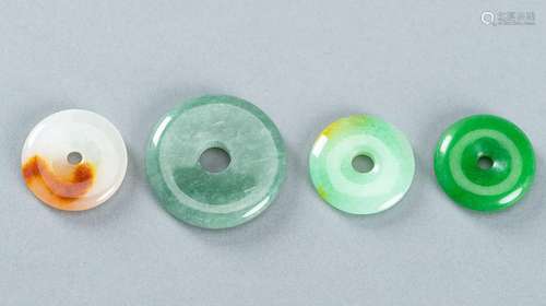 A GROUP OF FOUR JADEITE DISC PENDANTS