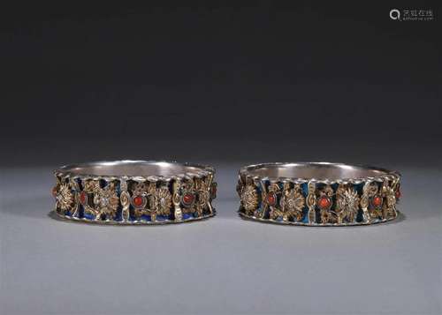 A pair of dragon patterned silver bracelets