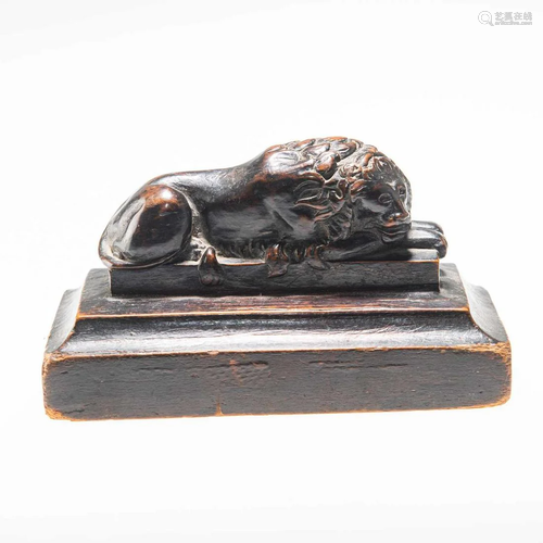 A 19TH CENTURY OAK CARVING OF A RECUMBENT LION