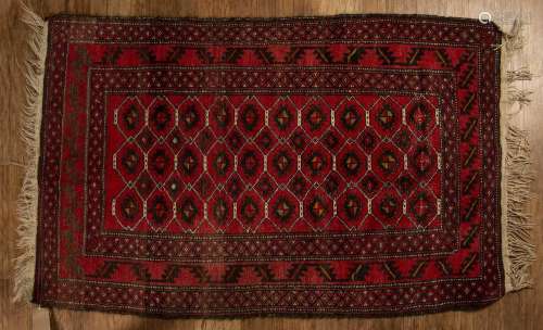 Red ground wool rug with geometric designs and stylised leaf...