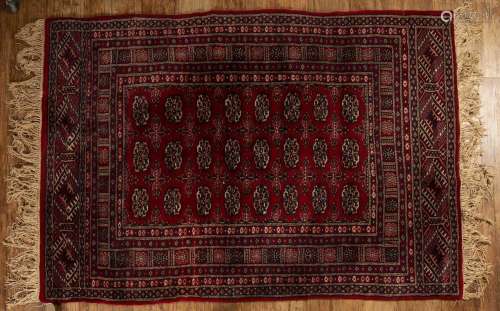 Red ground rug Pakistan, with a panel of elephant foot desig...