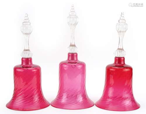 Three Victorian cranberry glass bells, the largest 33cm high