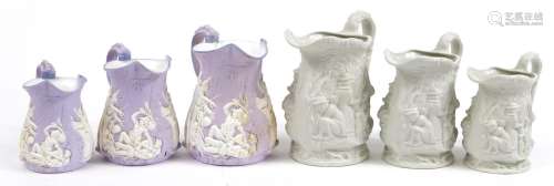 Two sets of three graduated bisque porcelain jugs including ...