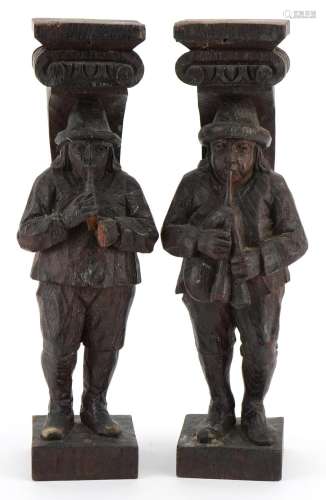 Pair of 18th century oak carvings of pipers, 29cm high