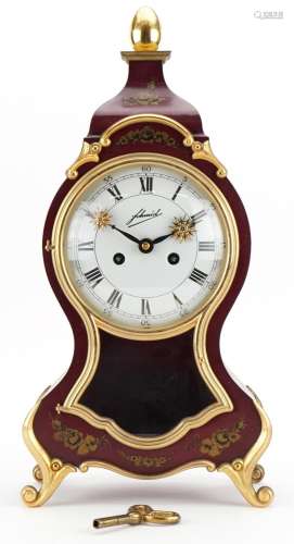 Red lacquer design striking mantle clock, the enamelled dial...