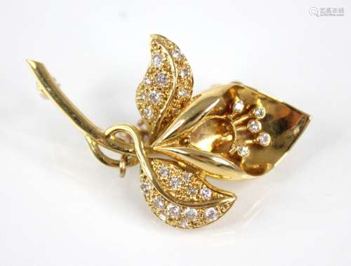 An 18ct gold diamond set lily brooch, the plain polished sha...