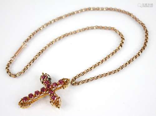 A ruby set gold coloured cross pendant, 45mm x 35mm, upon a ...