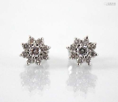 A pair of diamond floral cluster earrings, each comprising a...