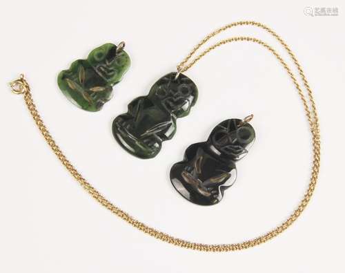 Three New Zealand jade Tiki pendants, one with attached yell...