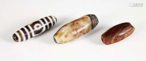 Three Tibetan Dzi beads, each banded agate bead of polished ...