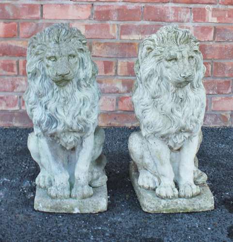 A pair of reconstituted stone lions, each modelled in a seat...