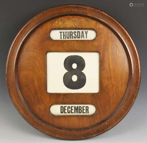 A circular mahogany perpetual wall calendar, mid 20th centur...