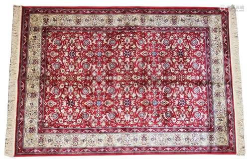 A red ground Kashmir all over floral design, enclosed by a t...