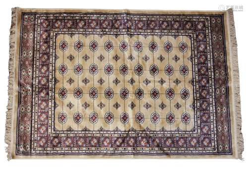 A gold ground Kashmir Bokhara design rug, the central field ...