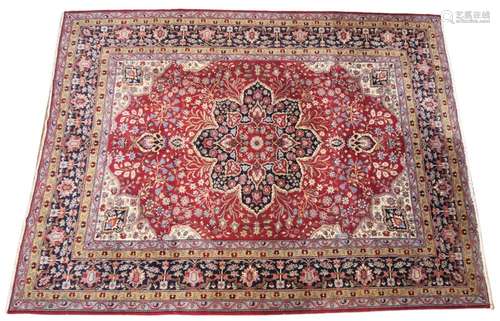 A large deep red ground Persian carpet, the central floral m...