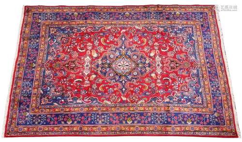 A red ground Persian Mashad carpet, the central blue medalli...