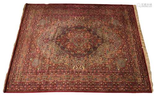 A Persian pattern wool carpet, in red, white and green colou...