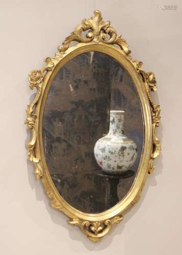 A giltwood Rococo style wall mirror, 20th century, the oval ...