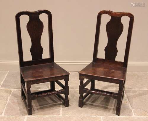 A near pair of early 18th century oak chairs, each with a va...