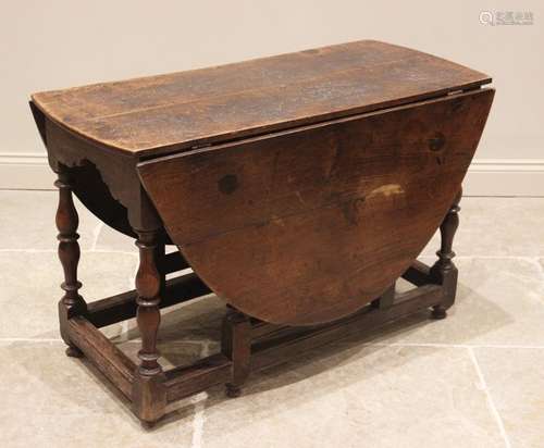 An 18th century oak drop leaf table, the oval top above a sh...