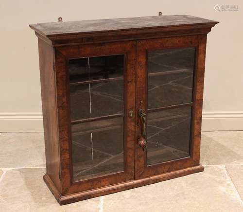 A burr walnut glazed cabinet, early 18th century, the moulde...