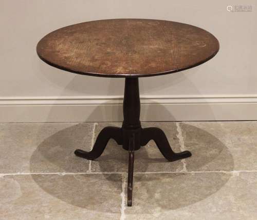 A George III oak tripod table, the circular top raised upon ...