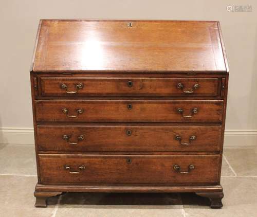 A George III oak and mahogany crossbanded bureau, the fall f...