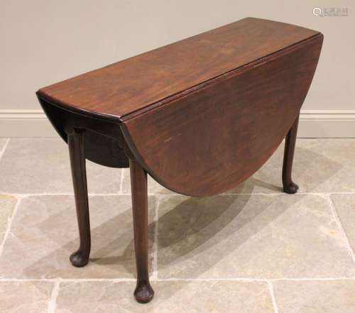 A George II mahogany drop leaf table, the oval top raised up...