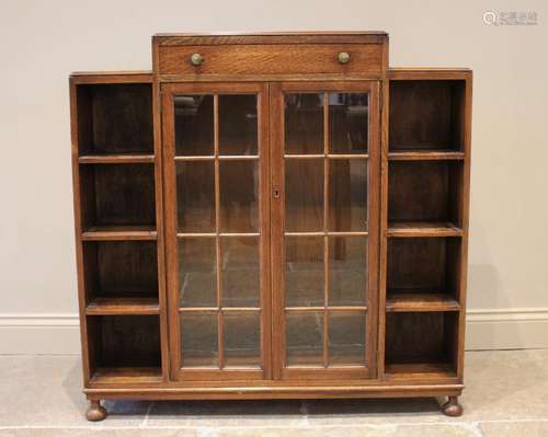 An Art Deco glazed oak bookcase, the architectural shaped to...