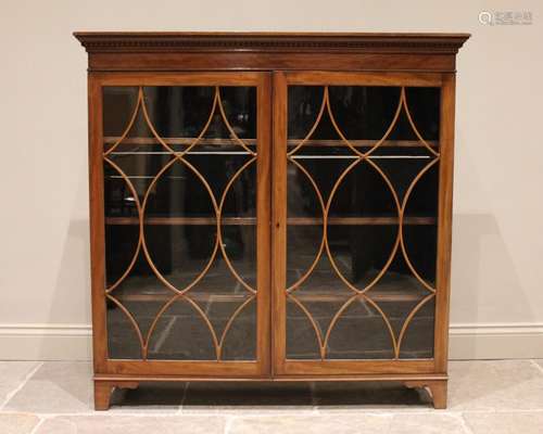 A mahogany glazed bookcase, early 20th century, with a denti...