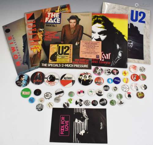 A collection of mostly music-related pin badges plus three c...