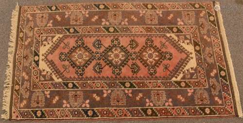 Afghan rug with three central guls on a pink and mauve groun...