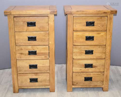 A pair of contemporary solid oak chests of five drawers with...