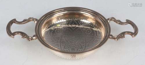 A George II silver lemon strainer, the pierced circular bowl...