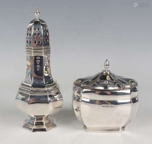 A silver tea caddy of oval form with canted sides beneath a ...
