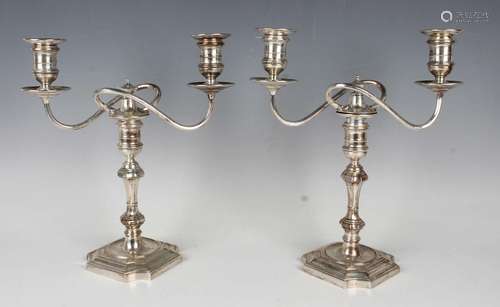 A pair of George VI silver twin branch candelabra, each scro...