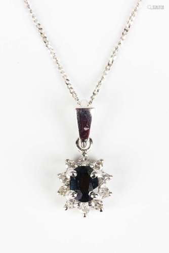 A 9ct white gold, sapphire and diamond oval cluster pendant,...