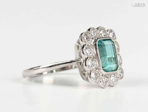 A platinum, emerald and diamond rectangular cluster ring, co...