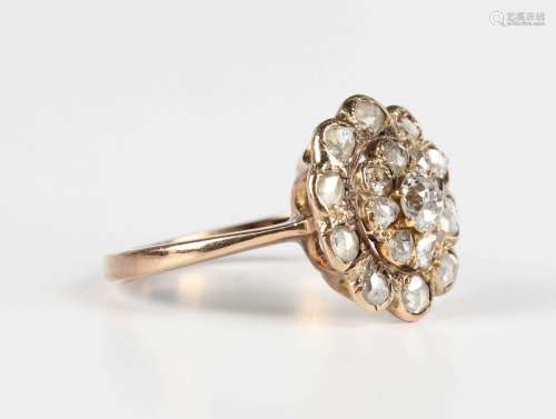 A gold and diamond oval cluster ring, claw set with the prin...