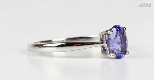 A platinum ring, claw set with an oval cut tanzanite, detail...
