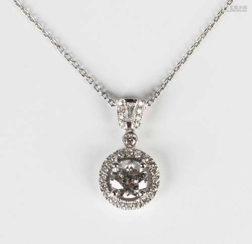 An 18ct white gold and diamond halo pendant, claw set with t...